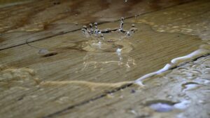 Eau répandue sur un plancher intérieur, illustrant un dégât d’eau dans une maison.